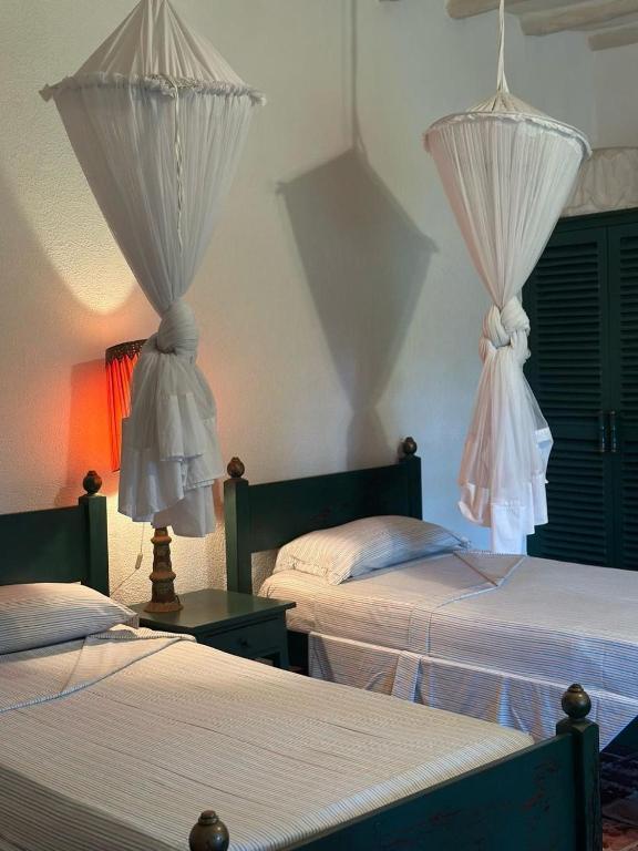 a bedroom with two beds with curtains on them at Villa Elizabeth by the Golf Club in Malindi