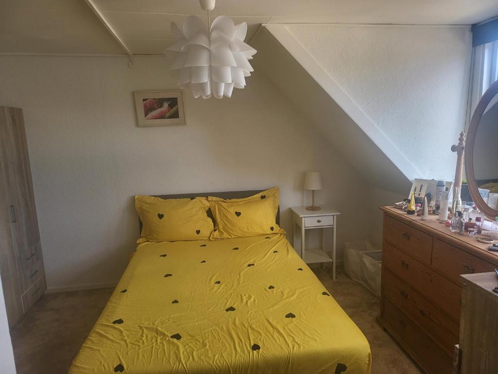 a bed with a yellow bedspread in a bedroom at Nice Apartment in Aalborg