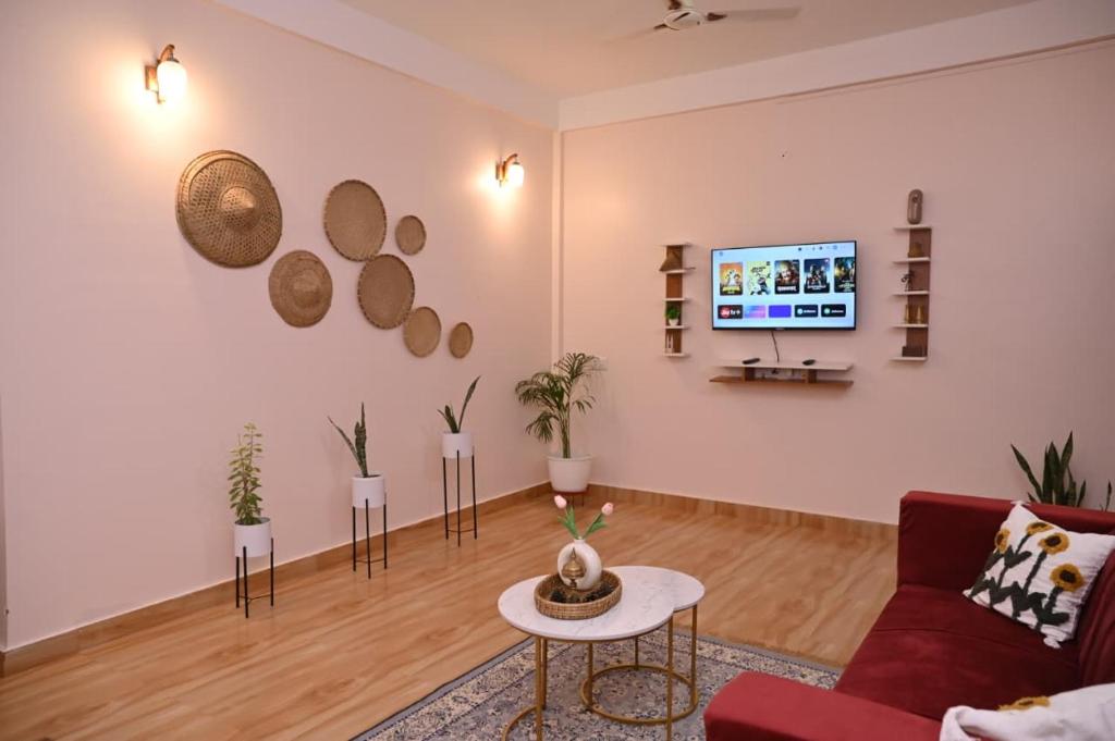 JorhatUptown Escape的客厅里有一张沙发，墙上有一台电视