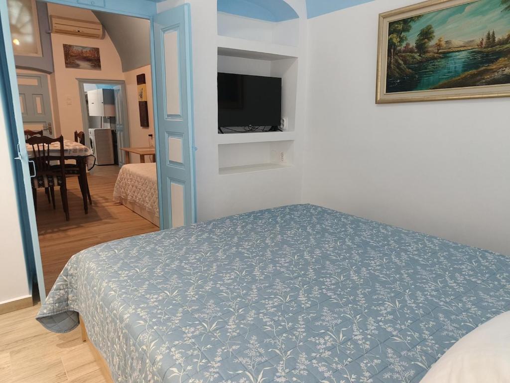 a bedroom with a bed and a flat screen tv at Odysseas Traditional house in Mesaria