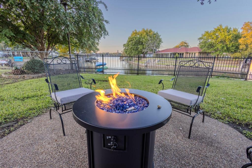 a fire pit in a backyard with two chairs at Lakefront Granbury Getaway in Granbury