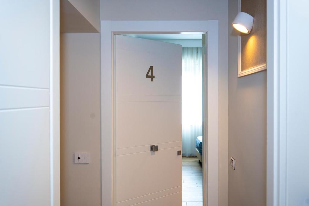 un couloir avec un miroir et une porte portant le numéro quatre dans l'établissement Lepanto Central, à Messina