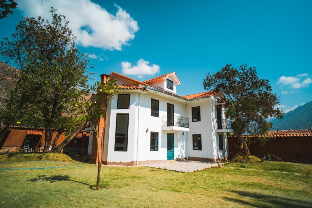 ein weißes Haus mit einem Baum im Hof in der Unterkunft Casa Julia in Huayllabamba