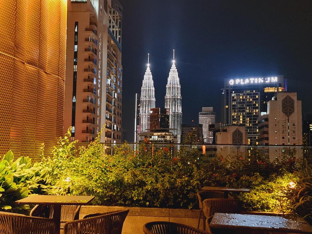 a city skyline at night with tables and chairs at KLCC View City Center At Majestic residence in Kuala Lumpur