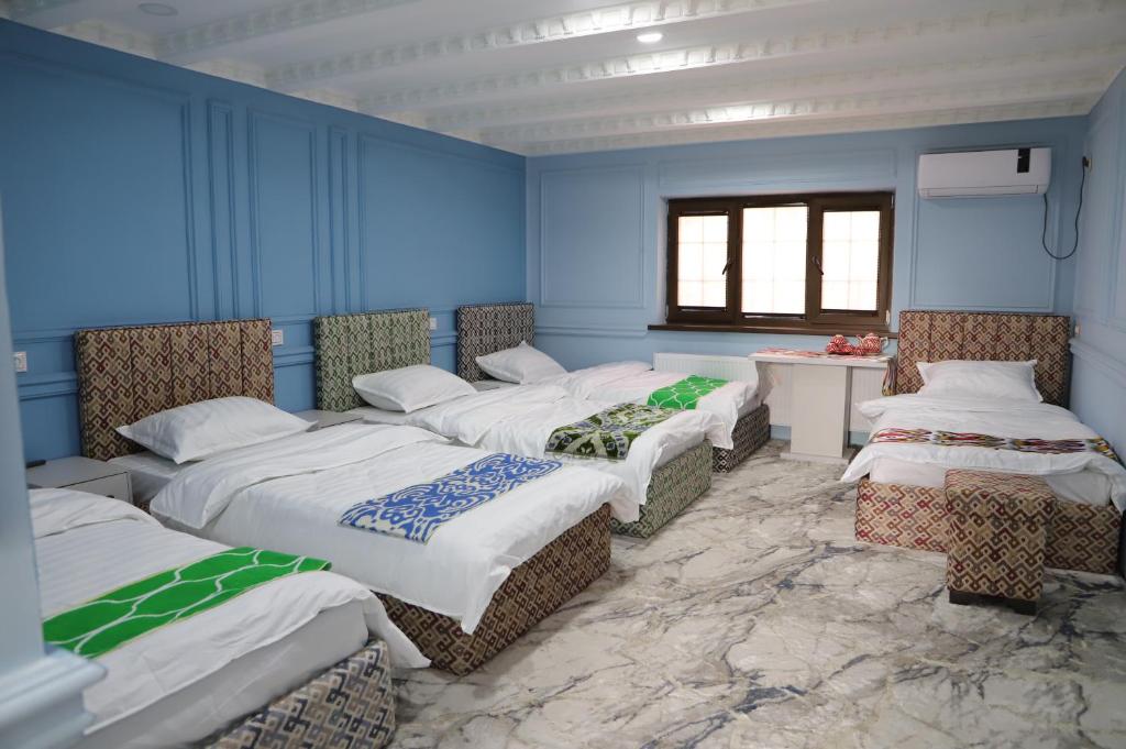 - un groupe de 4 lits dans une chambre dans l'établissement Movarounnahr - Гостевой дом, à Margilan