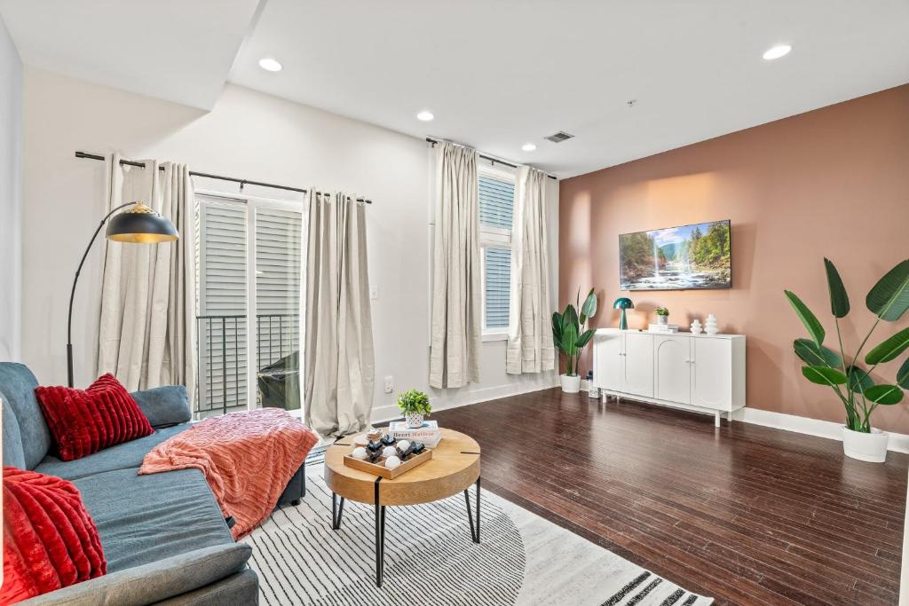 Luxury 3BR Rooftop Apartment Walk to MET and Metro في فيلادلفيا: غرفة معيشة مع أريكة زرقاء وطاولة