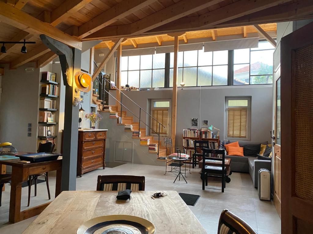 a living room with a wooden table and a staircase at eliamaria domus artificis in Lefkada Town