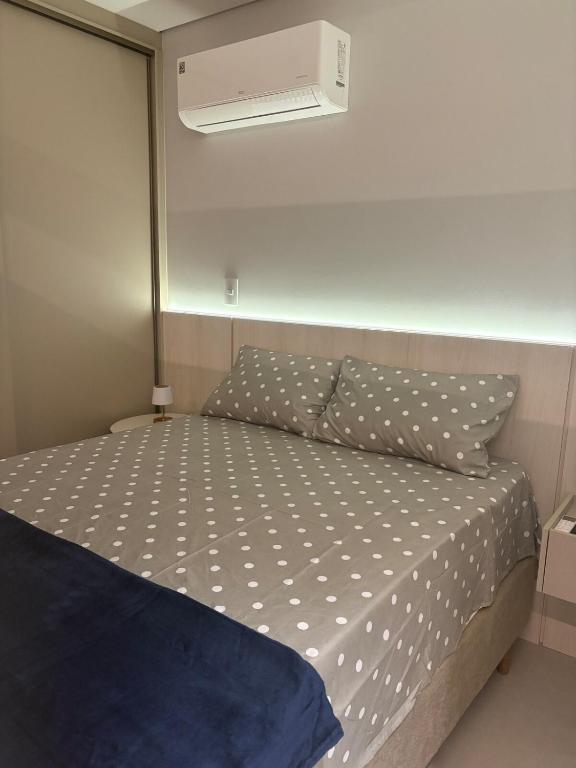 a bed in a small room with a white ceiling at Loft com Piscina no Rooftop centro de Blumenau in Blumenau