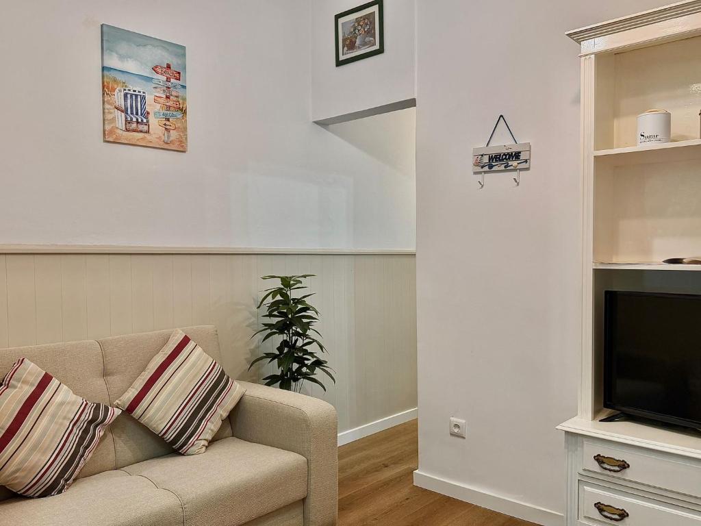 a living room with a couch and a television at Nazaré Stay Home - Alecrim T2 in Nazaré