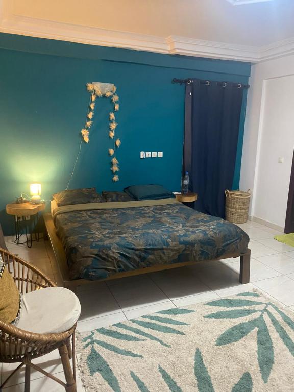 um quarto com uma cama com uma parede azul em OAsis du VoyAgeuR a peaceful appartement for stop over em Abidjan