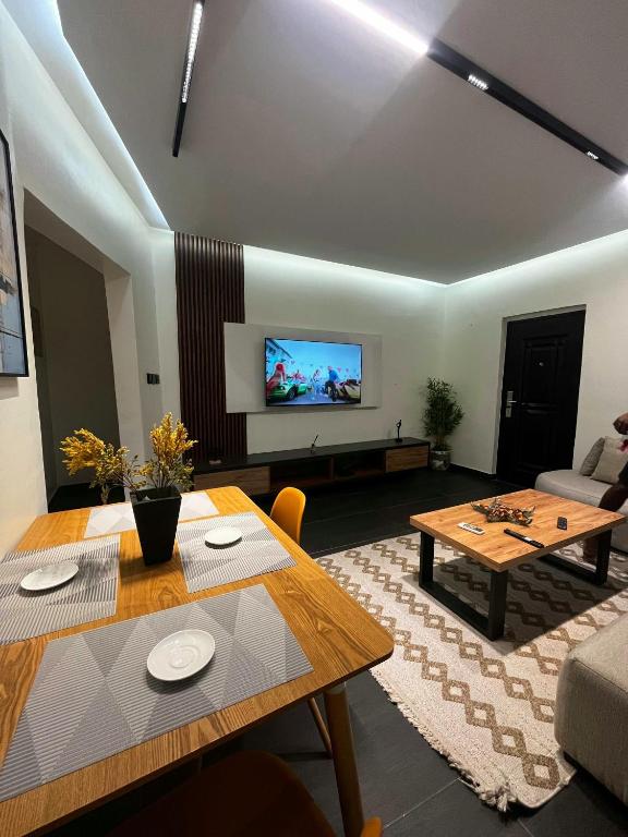 a living room with a table and a tv at Terra Verte Court in Accra