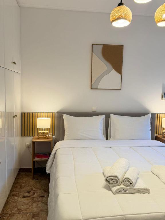 1 dormitorio con 1 cama blanca grande y 2 almohadas blancas en Boho Coastal Retreat with Jacuzzi, 1 min to Beach, en Atenas