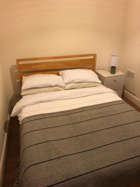 een slaapkamer met een bed met een houten hoofdeinde bij Trendy Terrace in Bristol