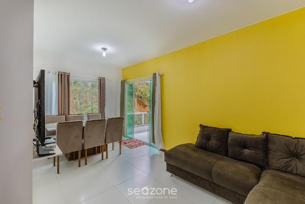 a living room with a couch and a yellow wall at Apto 2 Quartos a 200 m da Praia MAO0203 in Cururupe