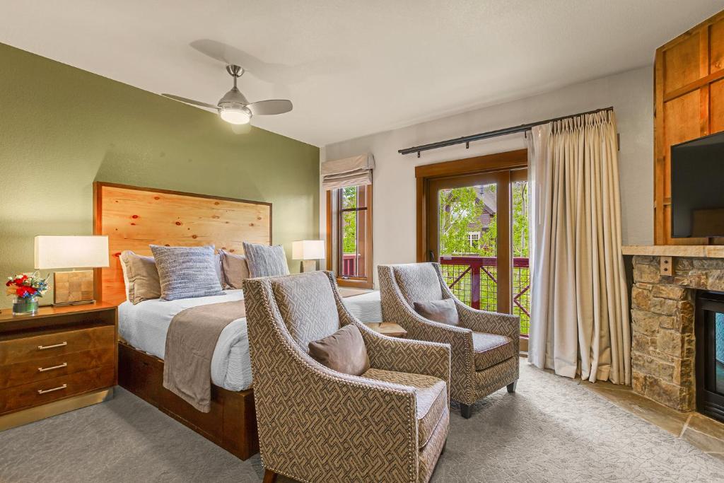 a bedroom with a bed and chairs and a fireplace at Hyatt Main Street Station Studio in Breckenridge