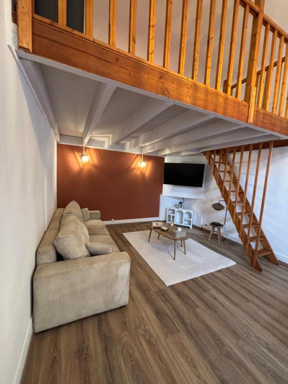a living room with a couch and a staircase at le cocon valenciennes gare in Valenciennes