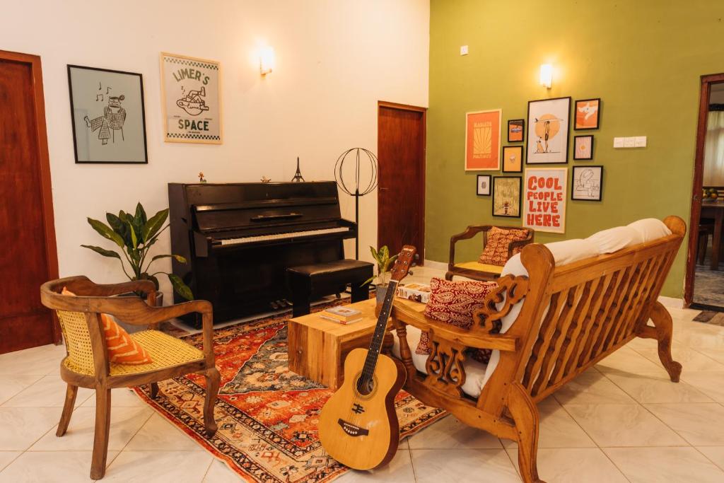 ein Wohnzimmer mit einer Gitarre und einem Klavier in der Unterkunft Lime Ahangama in Ahangama