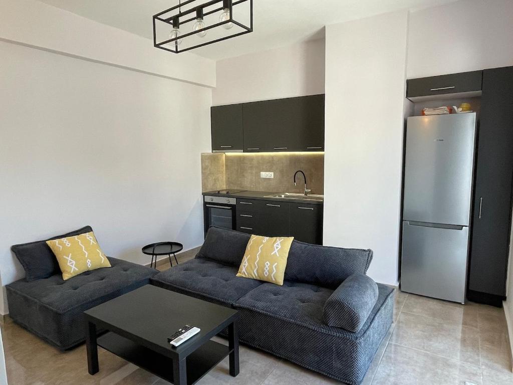 a living room with a couch and a kitchen at Casa del Rey in Piraeus