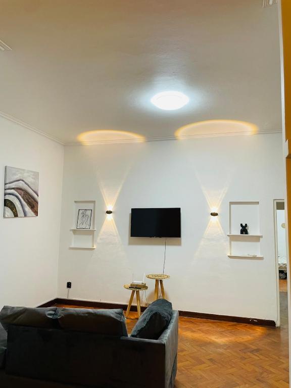 un salon avec un canapé et une télévision à écran plat dans l'établissement Lovely bedroom in a centrally located apartment, à Maputo