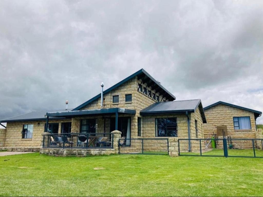 a large wooden house with a large grass yard at De Krantz 6 Estate in Clarens