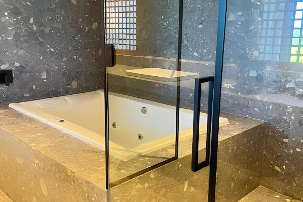 eine Duschkabine aus Glas mit Badewanne im Badezimmer in der Unterkunft Apartamento com banheira Dupla Vale dos Vinhedos in Garibaldi