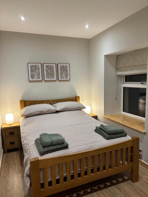 a bedroom with a bed with two green towels on it at Lighthouse View in Lochboisdale