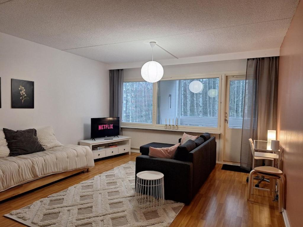 Una sala de estar con un sofá y un televisor en Ihana kaksio lähellä luontoa!, en Tampere
