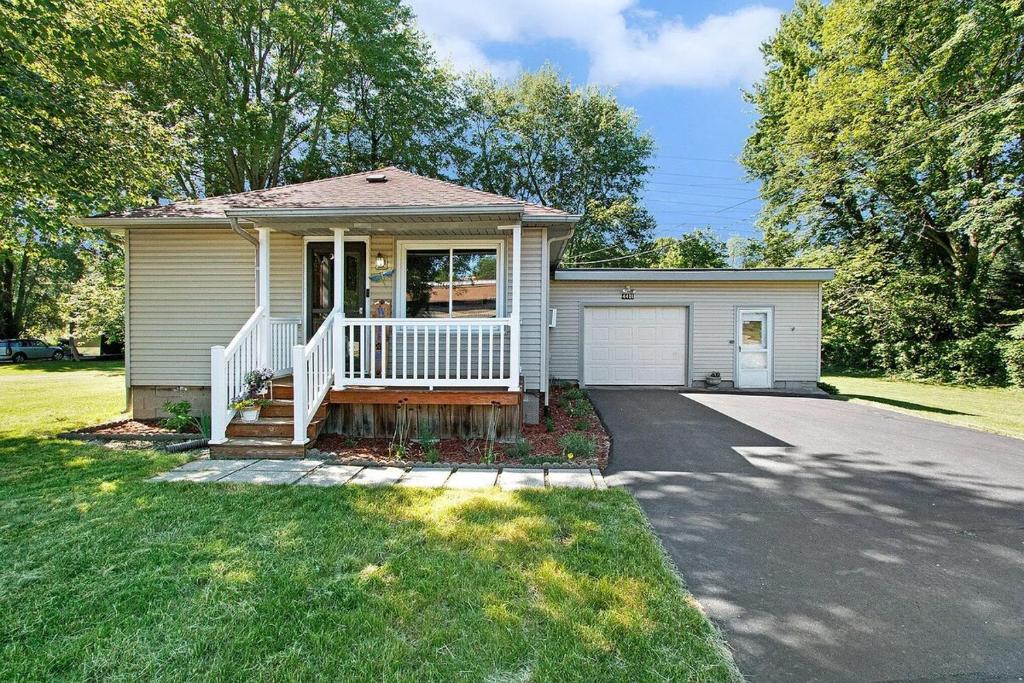 una piccola casa con portico e vialetto di Lake Trail Cottage a Michigan City