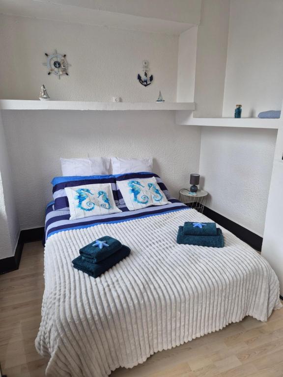 a bedroom with a bed with two towels on it at Le Lagon in Saint-Gaudens