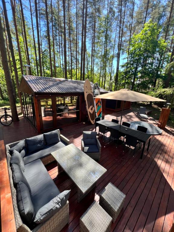 a deck with couches and tables and a gazebo at eL Pakrantė in Paplatelė