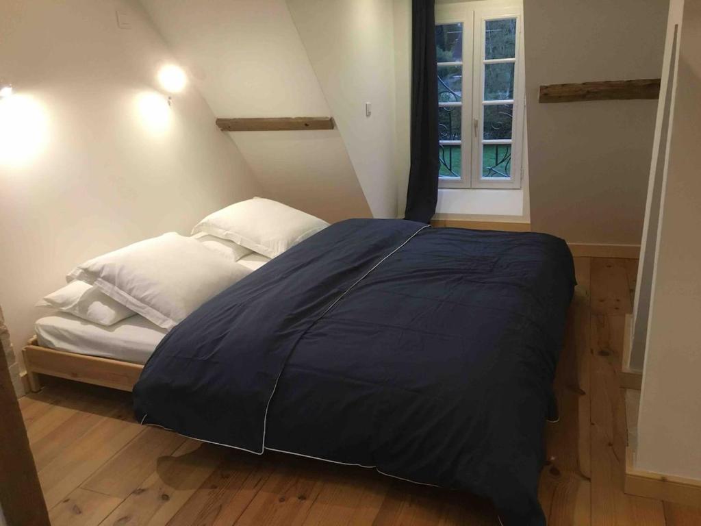 ein großes Bett in einem Zimmer mit Fenster in der Unterkunft Beauval Zoo & Châteaux, 2 bedroom house in La Celle-sous-Gouzon