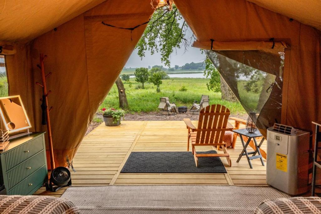 a tent with a deck with a chair and a table at Boutique Vineyard Stay at Painted Prairie in Currie