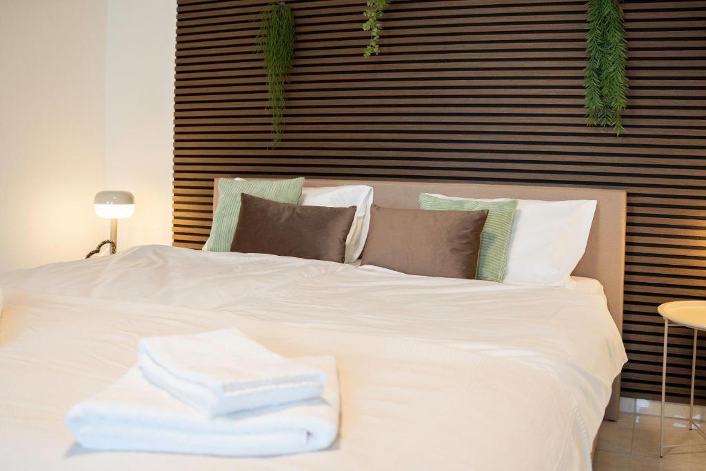 a white bed with a pile of towels on it at Comfort Stay, 6 Personen, 2PP, Hunde, zwischen Zürich-Luzern in Schafisheim