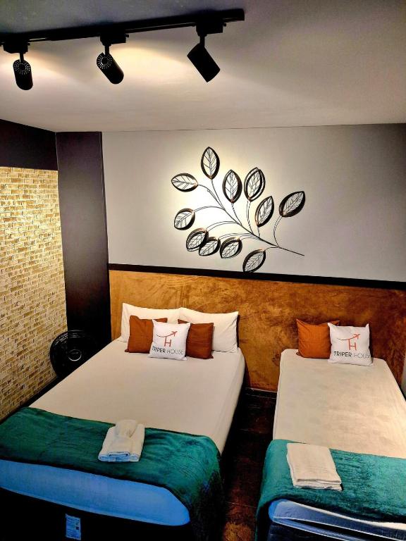 a room with two beds and a painting on the wall at studio estilo industrial Centro in Campos dos Goytacazes