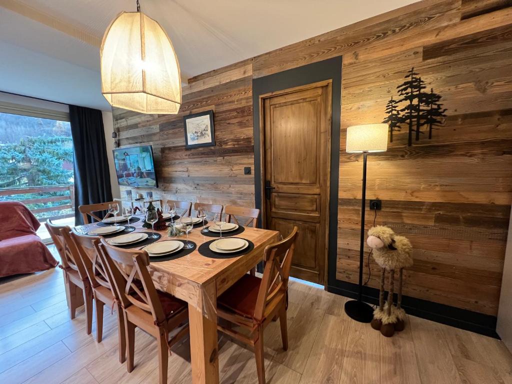 a dining room with a table and wooden walls at Mimi lodge familly in Valloire