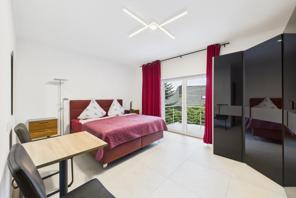 a bedroom with a bed and a table and a desk at Attraktive Neubauwohnung,Balkone,WIFI,Parken im Hof,Ganze Ruhe in Bremen