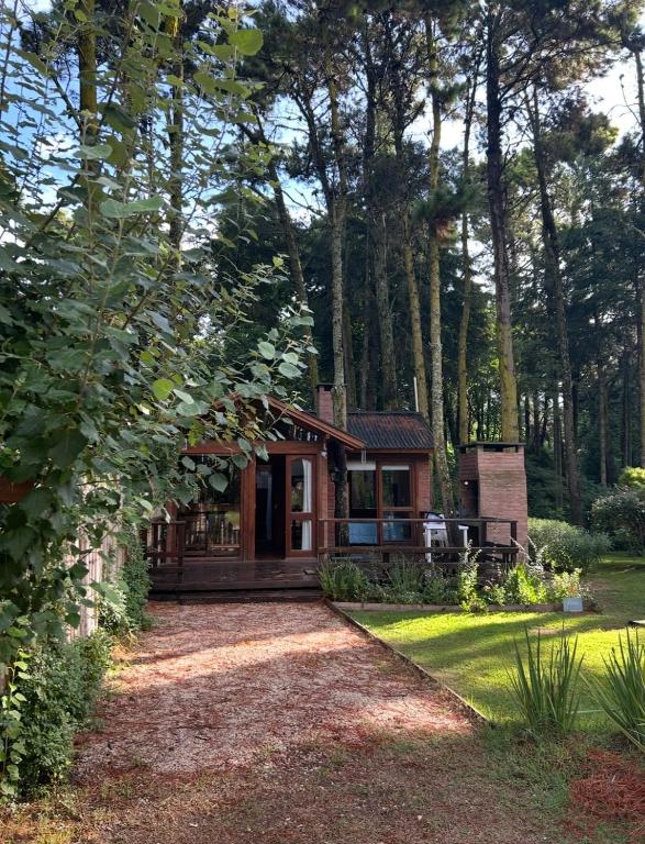 a cabin in the woods with a gravel driveway at Cabaña Ceibo in Mar de las Pampas