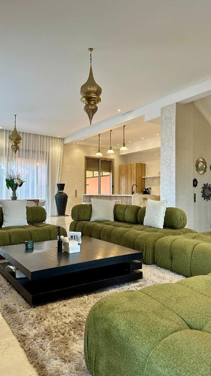 a living room with green couches and a coffee table at Exceptional Marrakech Villa 5 Bedrooms & Pool in Oulad Akkou