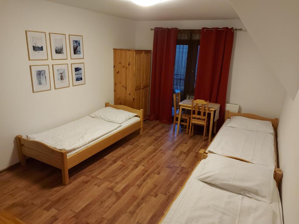 deux lits dans une chambre avec une table et une salle à manger dans l'établissement Janicek, à Ząb