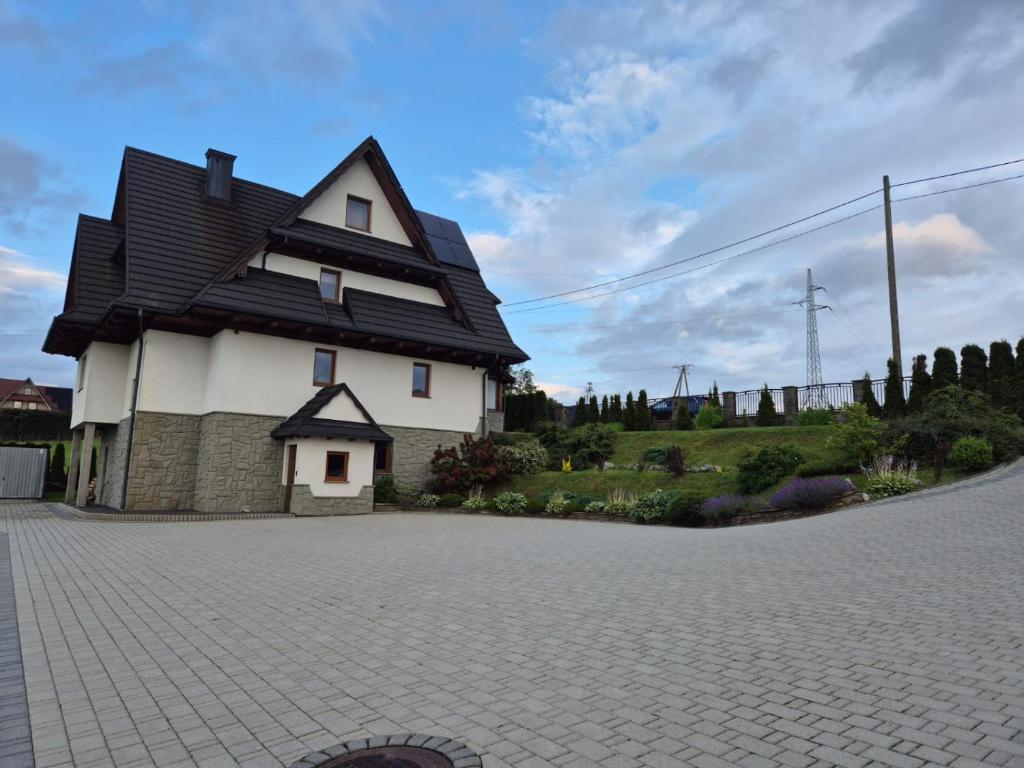 a house with a gambrel roof on a driveway at Janicek in Ząb