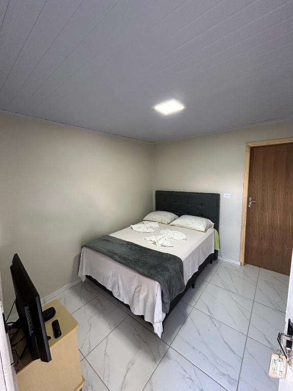 a bedroom with a bed and a desk and a television at Pousada e Restaurante Zanella in Candói