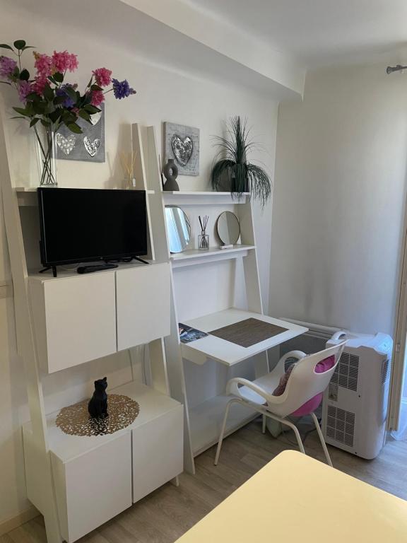 a living room with a tv and a desk at Studio calme au centre-ville in Manosque