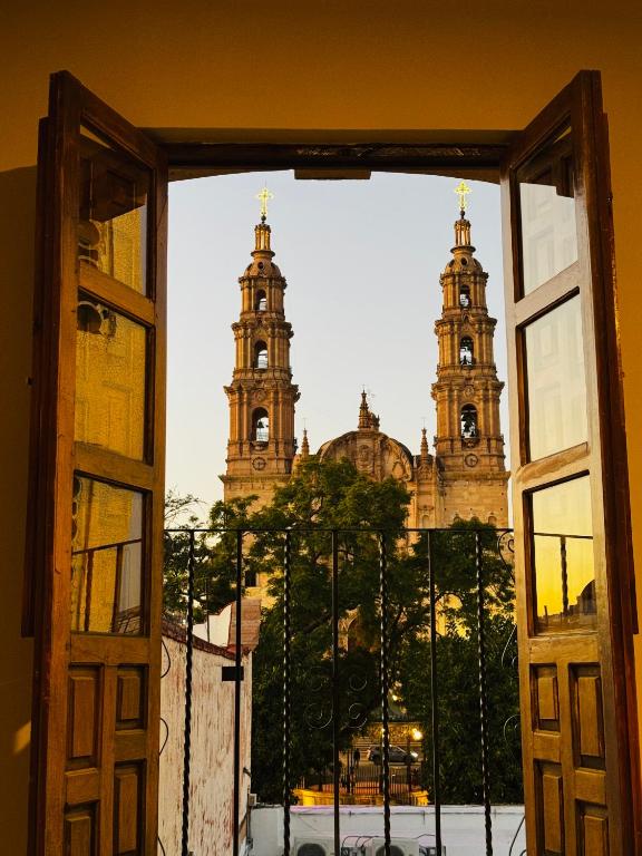 an open window with a view of two towers at CASA UMBRAL - Plaza principal in Lagos de Moreno