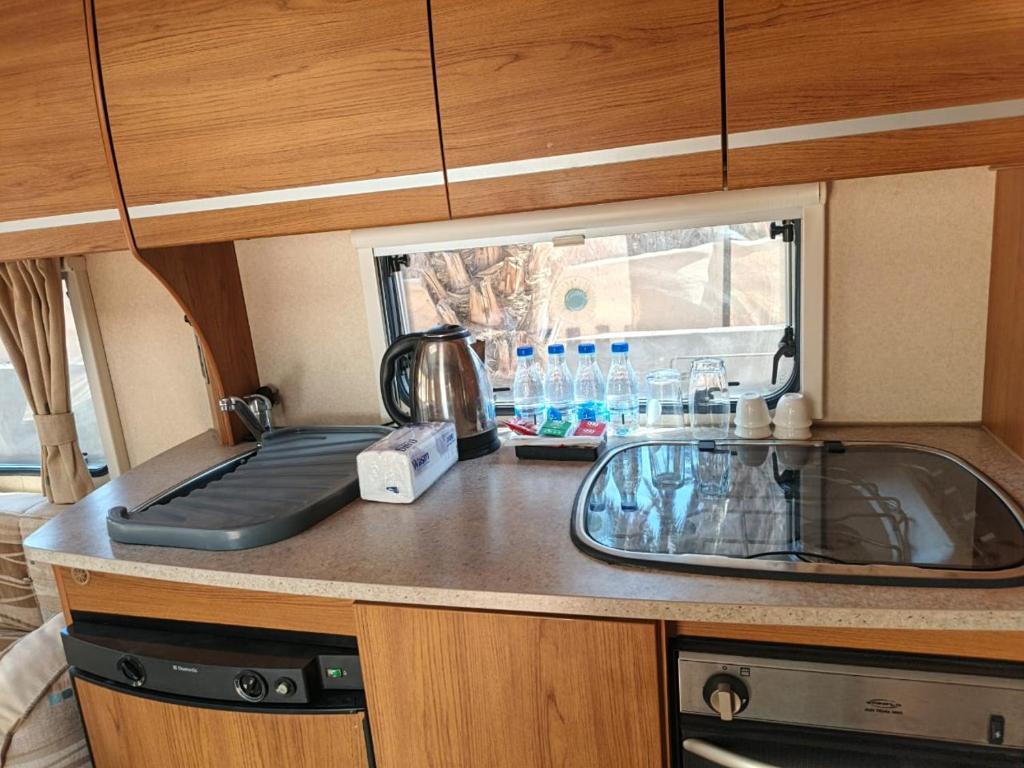 una cocina con fregadero y encimera en كرفان لحظة لقاء, en Al Ula