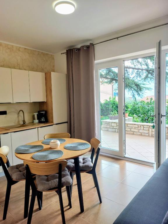a kitchen and dining room with a table and chairs at Tangerine Apartment in Rabac