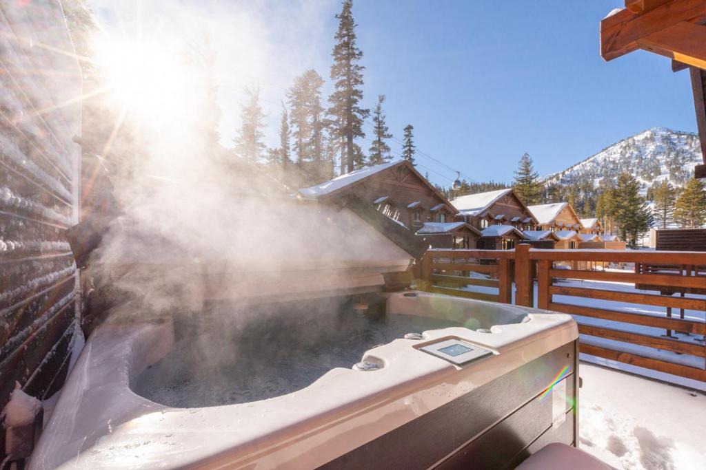 a hot tub on a deck with snow and trees at Mountainside 15 in Mammoth Lakes