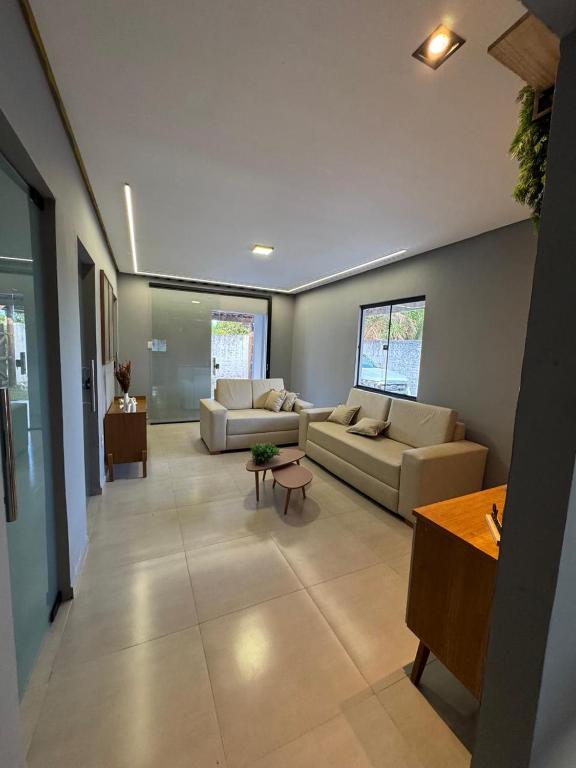 een woonkamer met twee banken en een tafel bij CASA de Praia em Jóia do Atlântico in Ilhéus