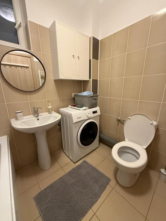 ein Badezimmer mit Toilette, Waschbecken und Waschmaschine in der Unterkunft Cozy 2Rooms in Popeşti-Leordeni