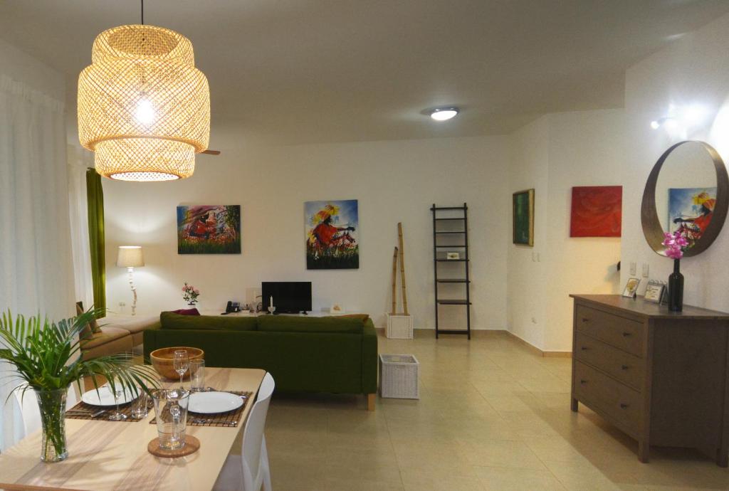 a living room with a green couch and a mirror at Infiniti Instyle in Sosúa