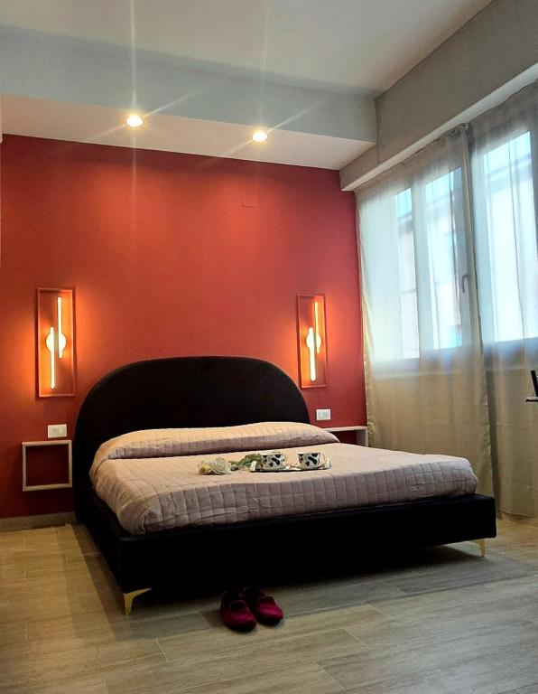 a bedroom with a bed with a red wall at SeaDoor in Livorno